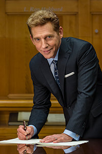 David Miscavige signing papers over conference table