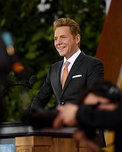David Miscavige in Amsterdam, Netherlands, at podium wearing dark gray suit