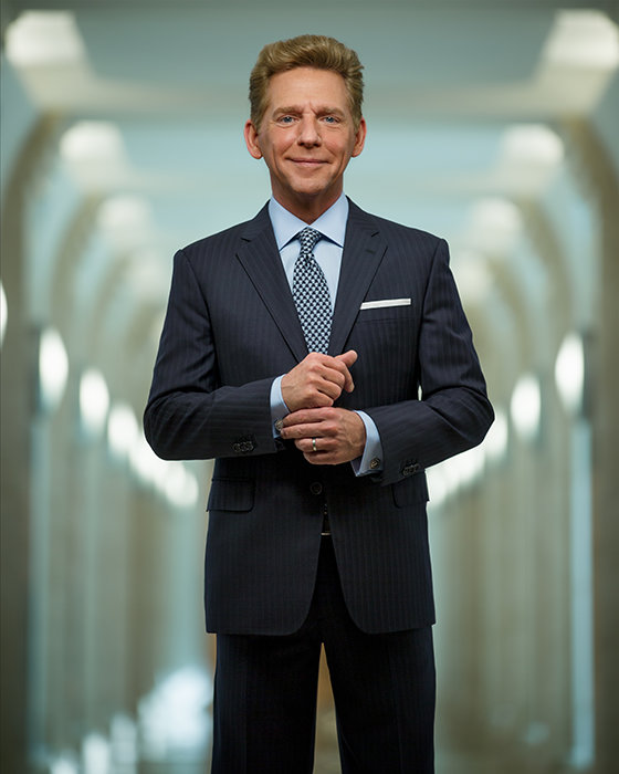 David Miscavige in dark blue suit, hand on shirt cuff