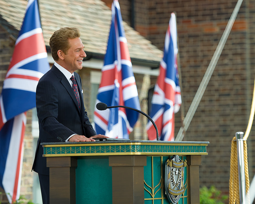David Miscavige in Sussex, England, at podium with British flags in background