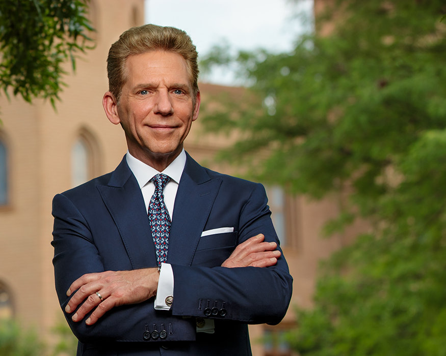 David Miscavige in Johannesburg, South Africa, close-up, wearing dark suit with arms crossed
