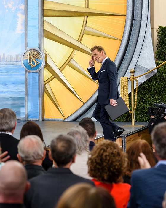David Miscavige in San Diego, California, walking up stairs to stage, saluting audience